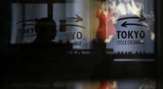 A visitor walks past logos at the TSE in Tokyo