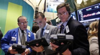 Traders work in front of a trading board showing Shutterstock Inc on the floor of the New York Stock Exchange