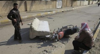 A man stands guard near the home of prominent Sunni Muslim lawmaker Ahmed al-Alwani after clashes with Iraqi security forces in the centre of Ramadi